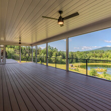 lower level deck with ceiling fan and a view of the mountains and pond